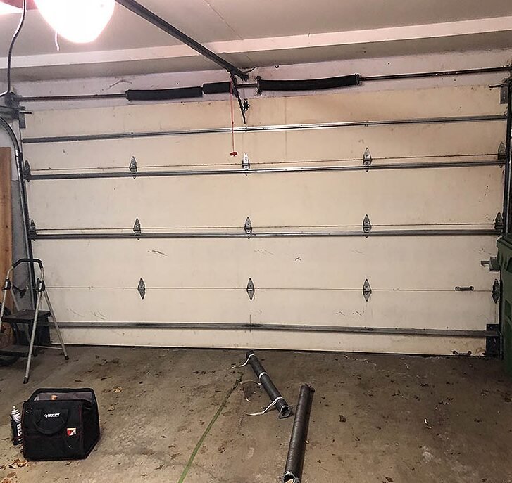 a skilled technician performing garage door spring repair with precision tools, highlighting the expertise of Garage Door Services Osprey in ensuring safe and reliable spring replacements for residential and commercial garage doors.